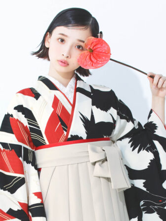 着物と袴のレンタルセット商品画像。袴はアイボリー色。着物はオフ色。烏×矢羽根柄のデザイン。上半身アップ画像。