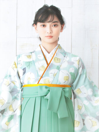 着物と袴のレンタルセット商品画像。袴はミントグリーン色。着物は水色。りんご椿柄のデザイン。上半身アップ画像。
