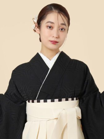 着物と袴のレンタルセット商品画像。袴はオフ色。着物は黒色。華亀甲柄のデザイン。上半身アップ画像。