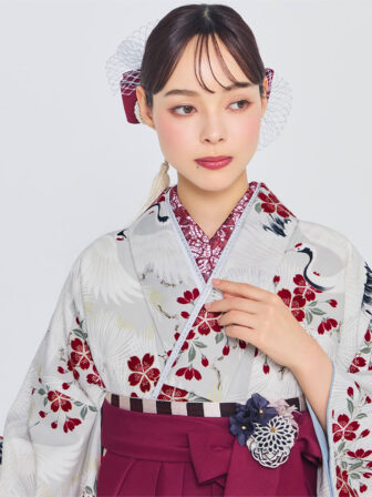 着物と袴のレンタルセット商品画像。袴はえんじ色。着物は銀ねず色。鶴に松桜柄のデザイン。上半身アップ画像。
