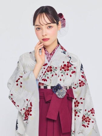 着物と袴のレンタルセット商品画像。袴はえんじ色。着物は銀ねず色。鶴に松桜柄のデザイン。上半身アップ画像。